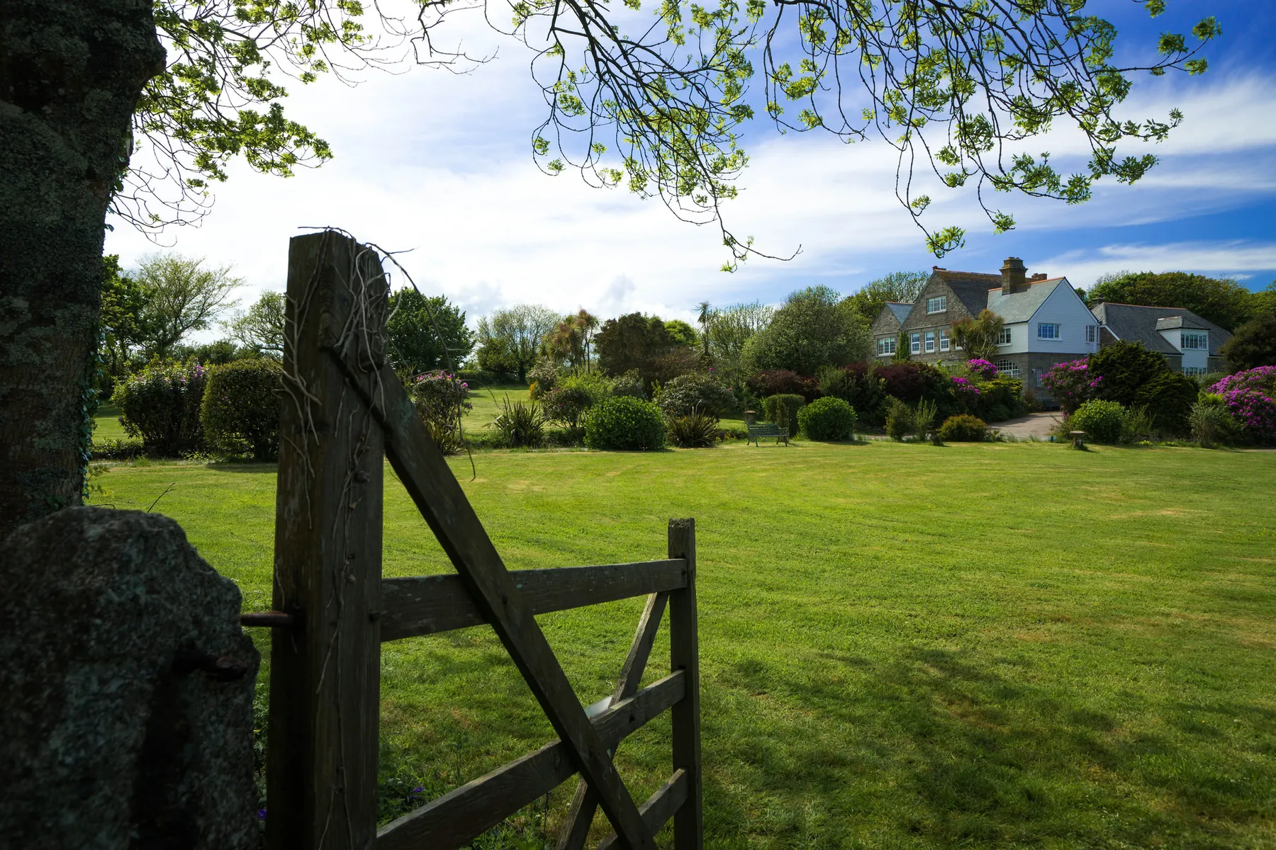 The granite gatepost and open lawn in the private grounds at Higher Faugan Parc