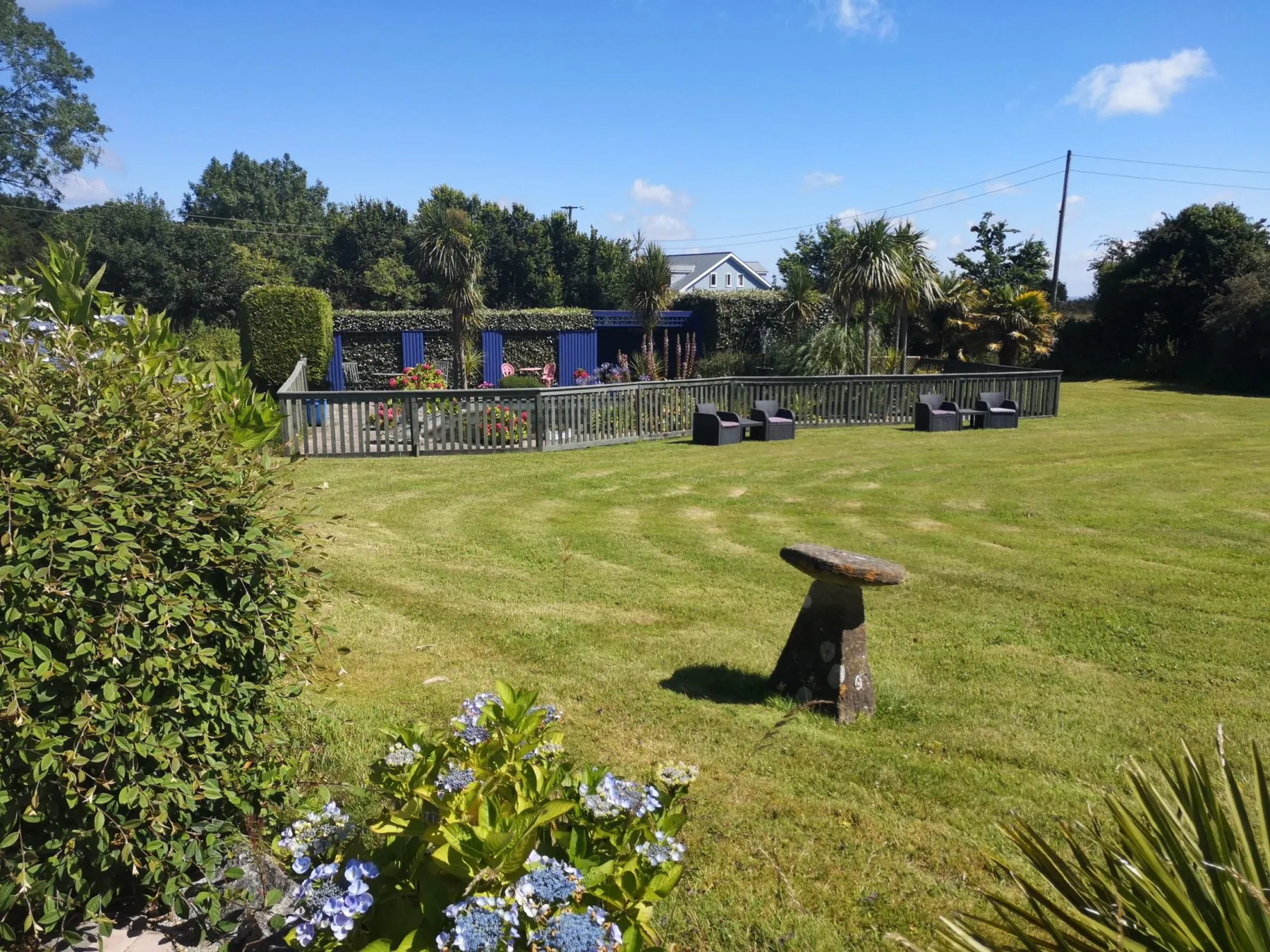 The large guest lawn at Higher Faugan Parc, mown in stripes, with the pond garden beyond