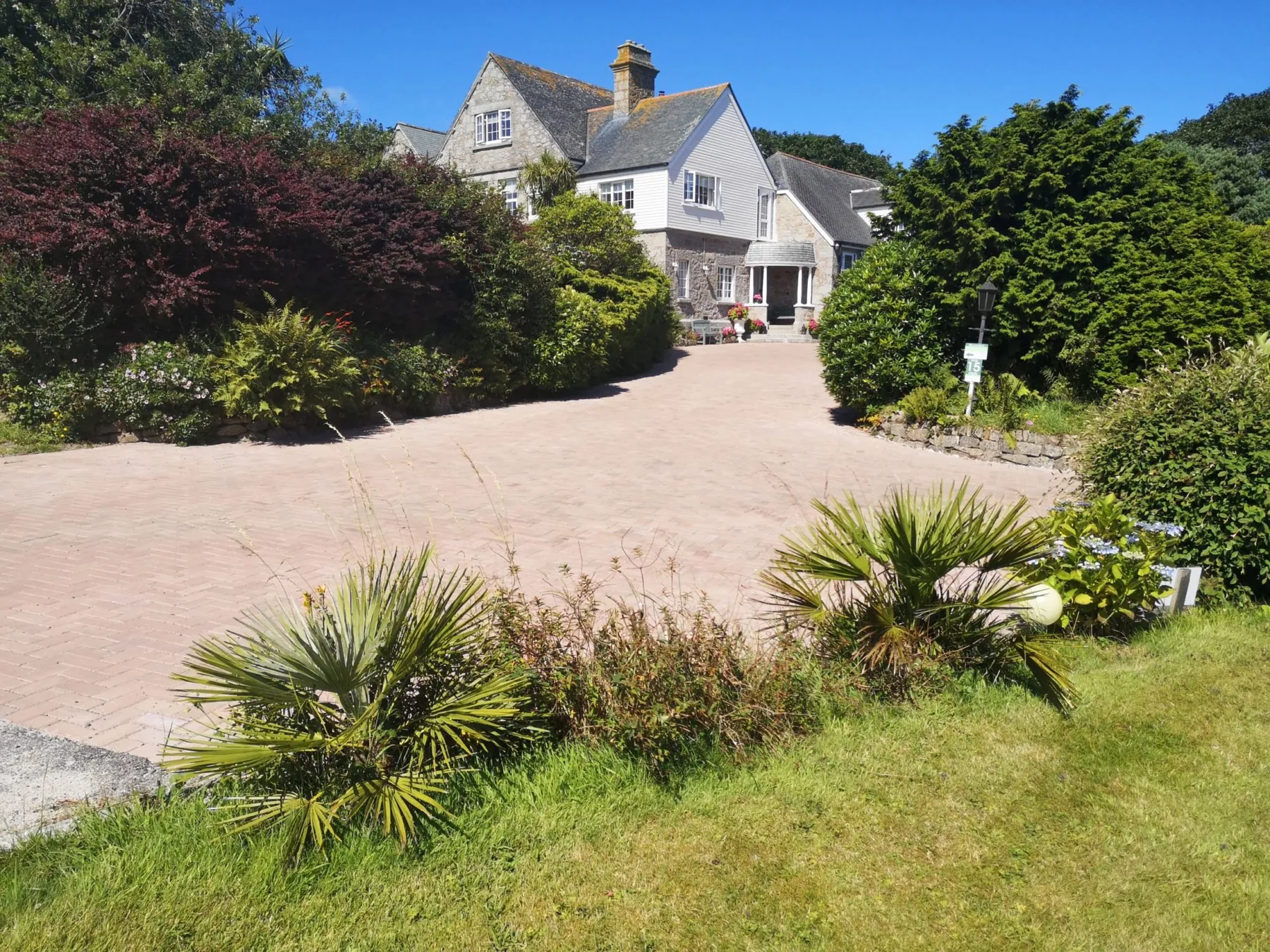The private drive and guest parking at Higher Faugan Parc, with the house beyond the planting