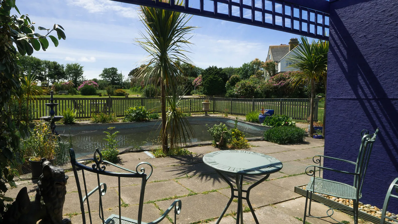 Terrace table and chairs beside the pond deck at Higher Faugan Parc