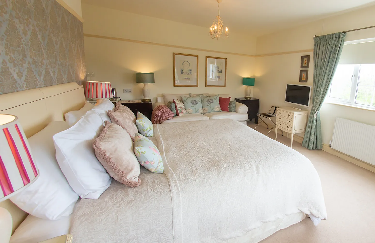 Room 7 at Higher Faugan Parc: the bed dressed in silk cushions beneath the window