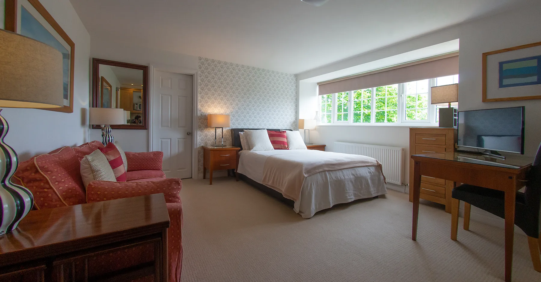 Room 1, a ground-floor luxury suite at Higher Faugan Parc, with king-size bed, sofa and garden windows